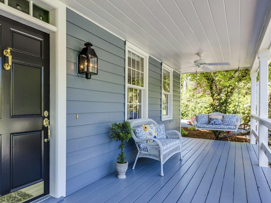 Painted blue weatherboard house with a white-trimmed porch